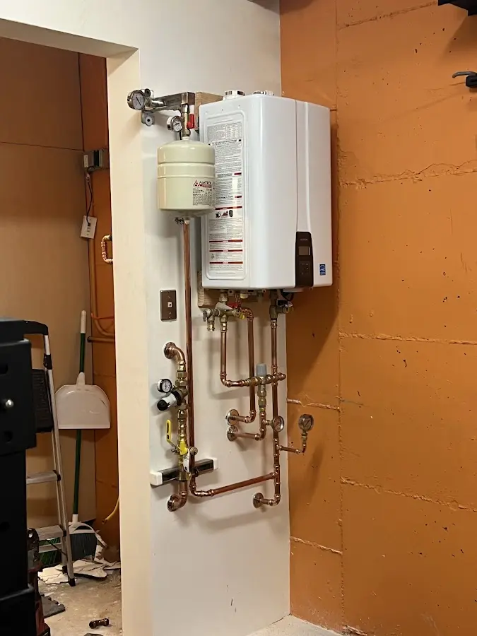 Plumbing technician inspecting water heater connections in Midway